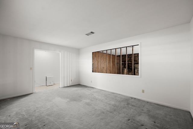carpeted empty room featuring baseboards and visible vents