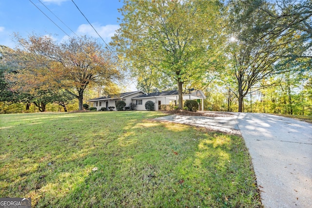view of front facade featuring concrete driveway and a front yard