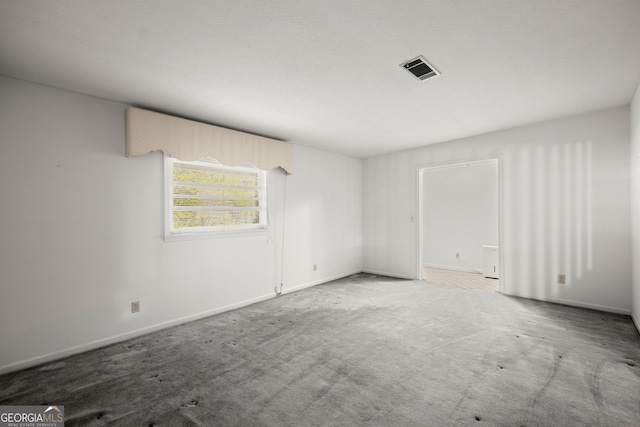 carpeted empty room with baseboards and visible vents