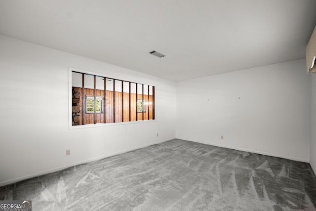 carpeted spare room featuring baseboards and visible vents