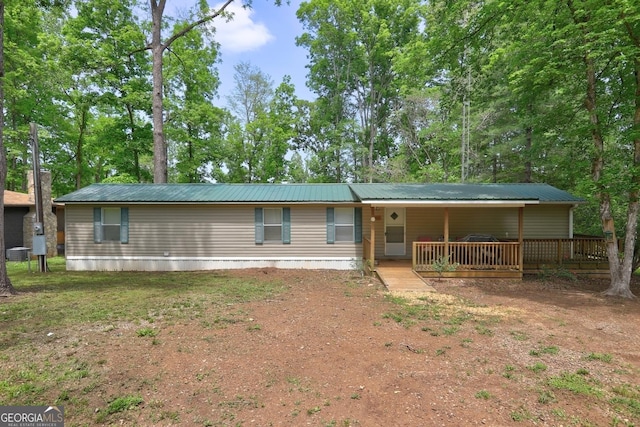 rear view of property featuring a deck and metal roof