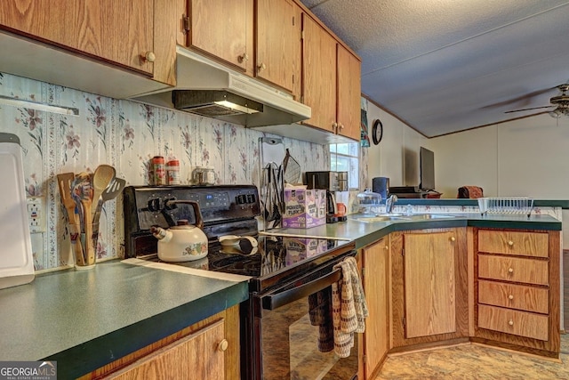 kitchen featuring a ceiling fan, electric range, a peninsula, under cabinet range hood, and a sink