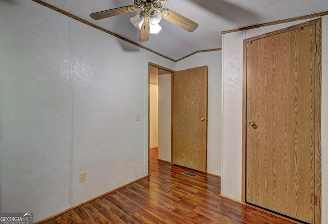 unfurnished bedroom featuring ceiling fan, crown molding, wood finished floors, a closet, and lofted ceiling