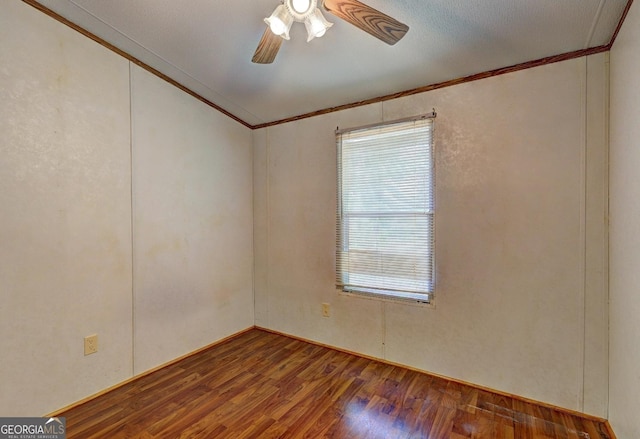 spare room featuring ornamental molding, ceiling fan, and wood finished floors
