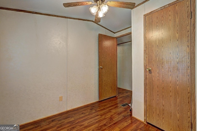 unfurnished bedroom with ornamental molding, a closet, wood finished floors, and visible vents