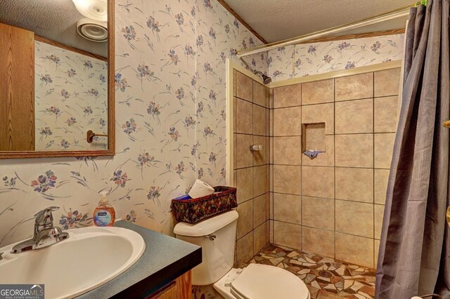 bathroom featuring a textured ceiling, wallpapered walls, toilet, and vanity