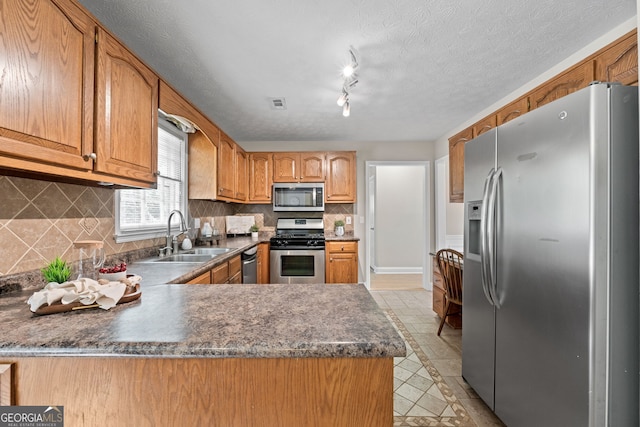 kitchen with visible vents, decorative backsplash, dark countertops, a sink, and stainless steel appliances