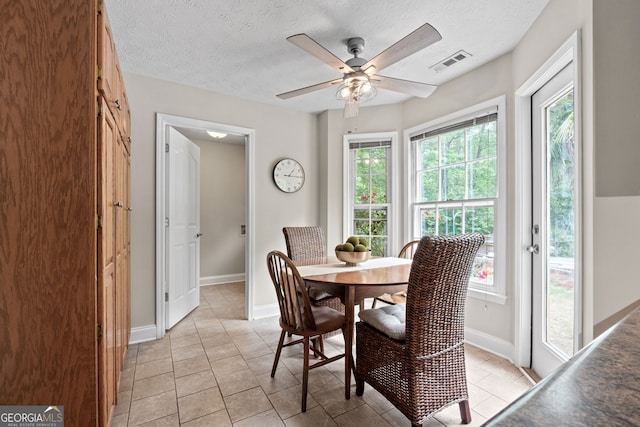 dining space with visible vents, a textured ceiling, ceiling fan, and a wealth of natural light