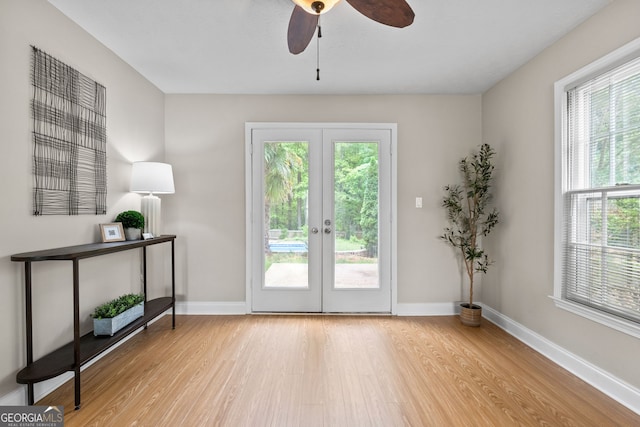 doorway featuring baseboards, a ceiling fan, wood finished floors, and french doors