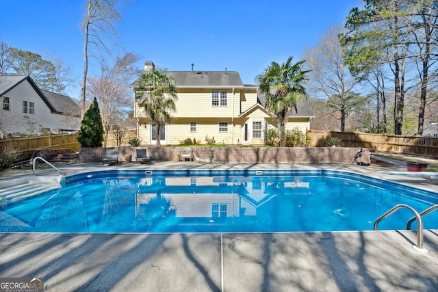 view of pool with a fenced in pool, a diving board, and a fenced backyard