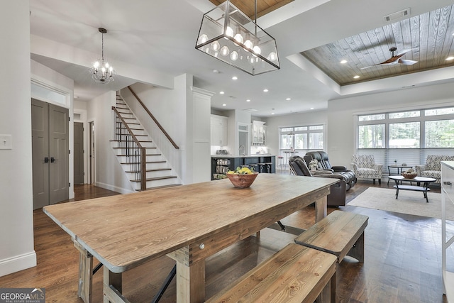 dining area featuring visible vents, stairs, dark wood-type flooring, and baseboards
