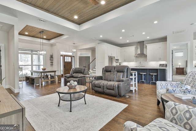 living room with recessed lighting, a tray ceiling, visible vents, and wood ceiling