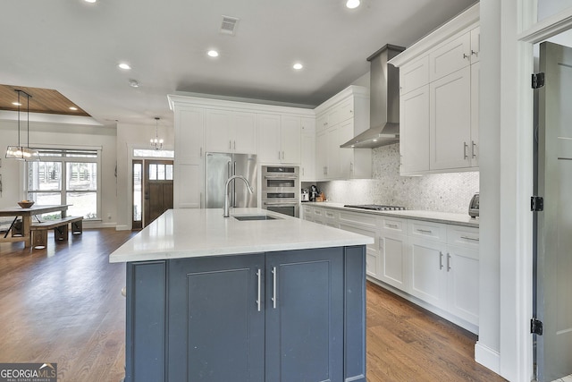kitchen with visible vents, recessed lighting, wall chimney range hood, and stainless steel appliances