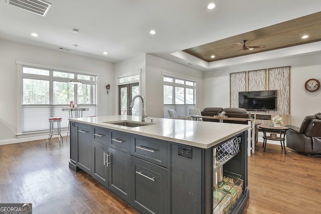 kitchen featuring visible vents, open floor plan, light countertops, a sink, and a wealth of natural light