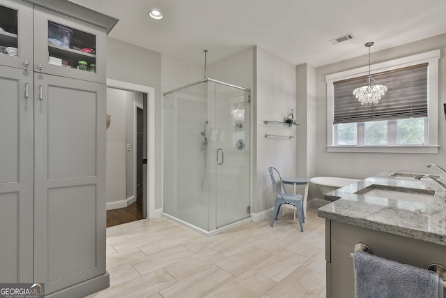 full bath with a sink, baseboards, a shower stall, and visible vents