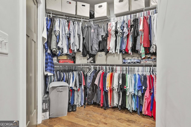 walk in closet with wood finished floors