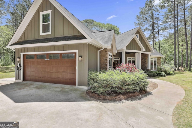 craftsman inspired home featuring a garage, board and batten siding, roof with shingles, and concrete driveway