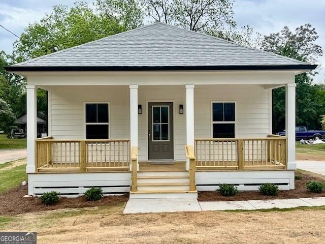 view of front of home with a shingled roof and a porch