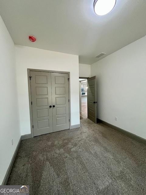unfurnished bedroom featuring baseboards, carpet, visible vents, and a closet