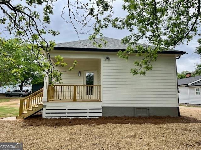 rear view of property featuring a porch