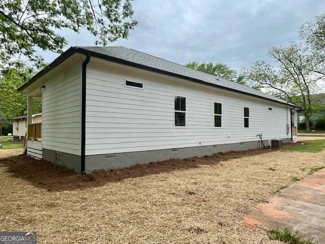 view of property exterior with crawl space and cooling unit
