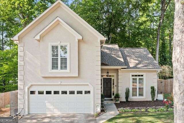 3376 Hickory Ln, Powder Springs, GA 30127 - view of front of house featuring fence, an attached garage, driveway, and stucco siding