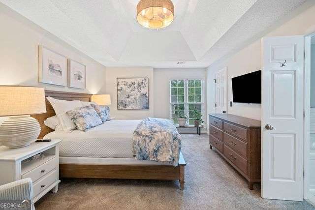3376 Hickory Ln, Powder Springs, GA 30127 - bedroom with light colored carpet, a textured ceiling, and a raised ceiling