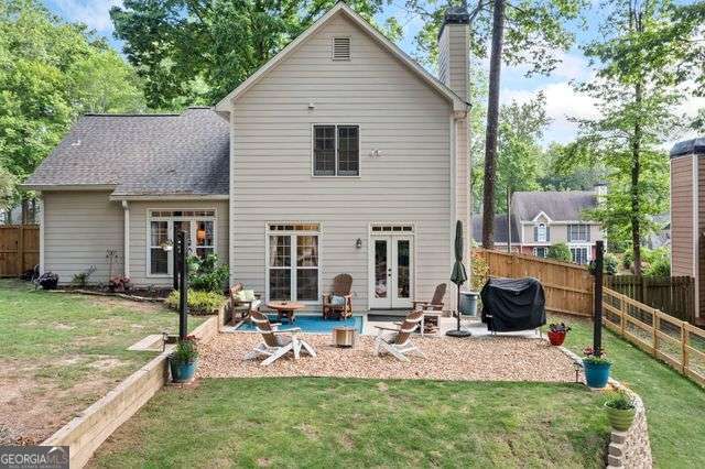 3376 Hickory Ln, Powder Springs, GA 30127 - rear view of house with a fenced backyard, a yard, french doors, and a chimney