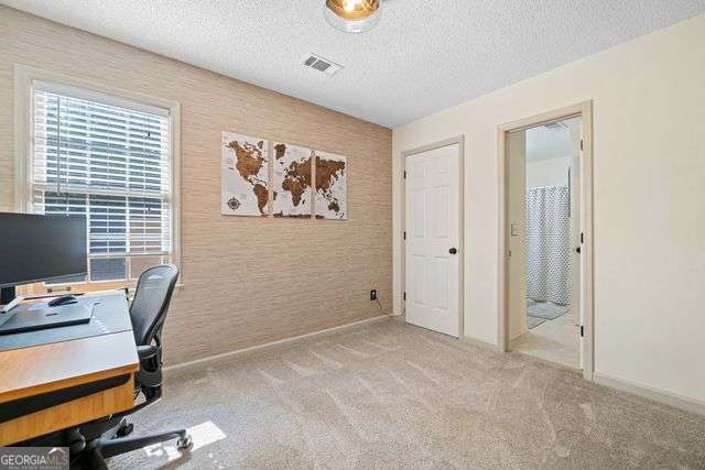 3376 Hickory Ln, Powder Springs, GA 30127 - home office featuring baseboards, a textured ceiling, carpet floors, and visible vents