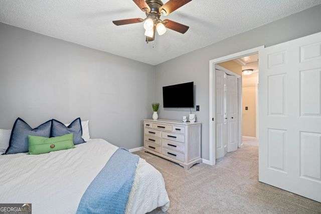 3376 Hickory Ln, Powder Springs, GA 30127 - bedroom featuring baseboards, ceiling fan, light carpet, and a textured ceiling