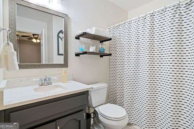 3376 Hickory Ln, Powder Springs, GA 30127 - bathroom featuring vanity, ceiling fan, a shower with curtain, and toilet
