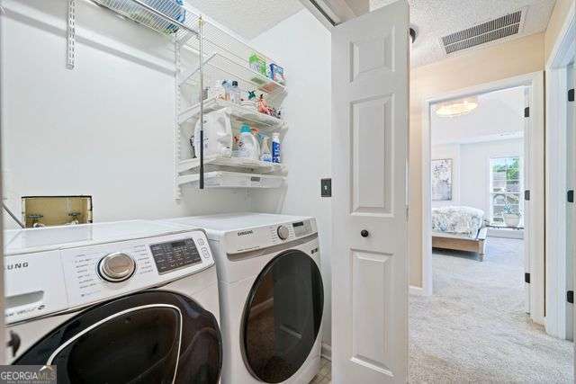 3376 Hickory Ln, Powder Springs, GA 30127 - laundry room with washing machine and clothes dryer, laundry area, light colored carpet, and visible vents