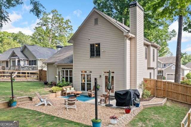 3376 Hickory Ln, Powder Springs, GA 30127 - rear view of property featuring fence, a chimney, a yard, and a patio area