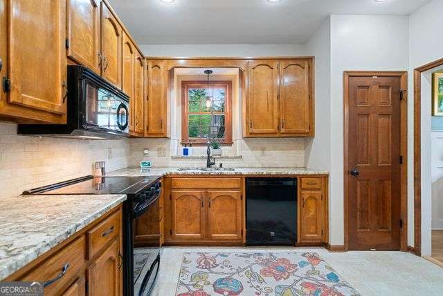 3376 Hickory Ln, Powder Springs, GA 30127 - kitchen featuring a sink, black appliances, and brown cabinets