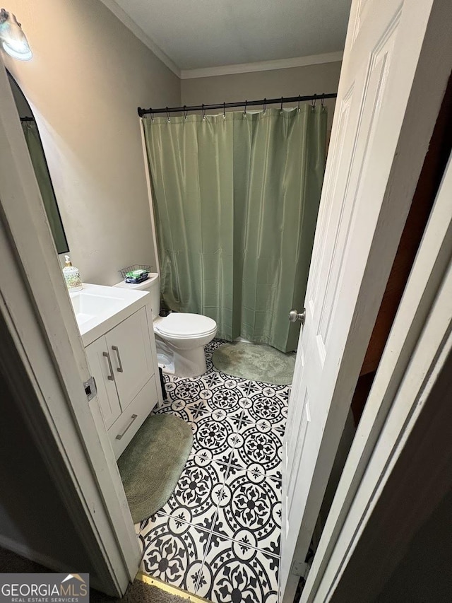 bathroom featuring vanity, ornamental molding, and toilet