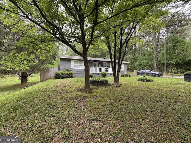 view of yard featuring fence and covered porch