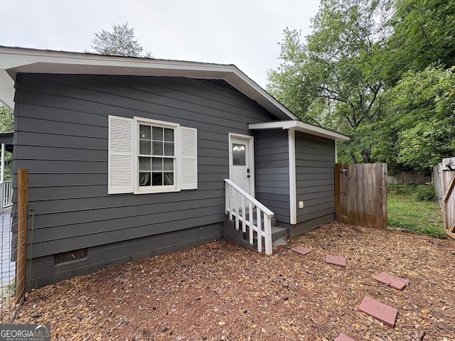 view of front of property with fence, crawl space, and entry steps