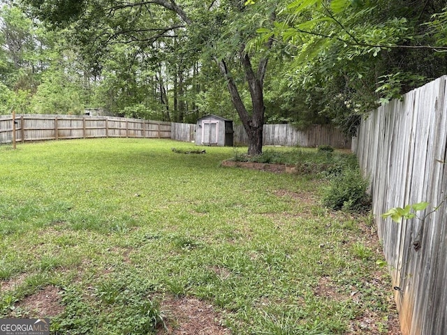 view of yard featuring a fenced backyard, an outbuilding, and a shed