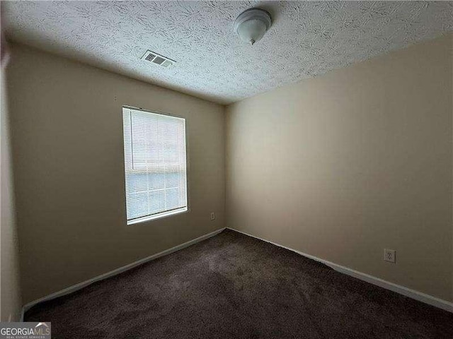 5280 Tussahaw Xing, Mcdonough, GA 30252 - empty room with baseboards, dark colored carpet, a textured ceiling, and visible vents