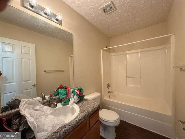 5280 Tussahaw Xing, Mcdonough, GA 30252 - bathroom with vanity, toilet, a textured ceiling, wood finished floors, and visible vents