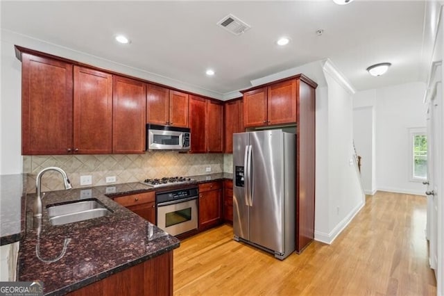 655 Mead St SE Unit 58, Atlanta, GA 30312 - kitchen with stainless steel appliances, a sink, light wood finished floors, decorative backsplash, and dark stone countertops