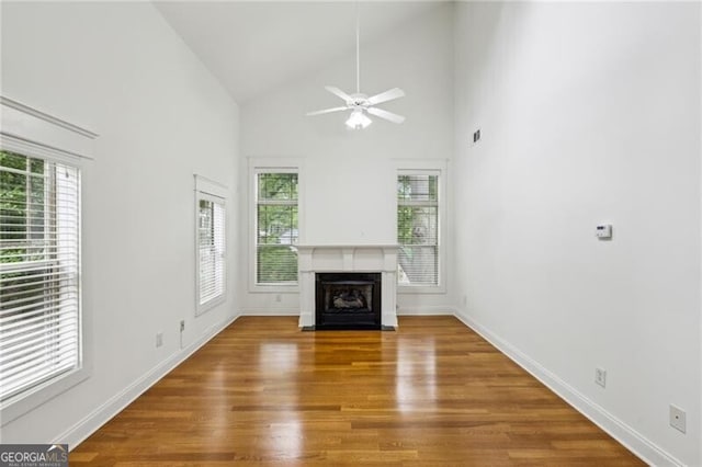 655 Mead St SE Unit 58, Atlanta, GA 30312 - unfurnished living room featuring plenty of natural light, a fireplace with flush hearth, ceiling fan, wood finished floors, and high vaulted ceiling