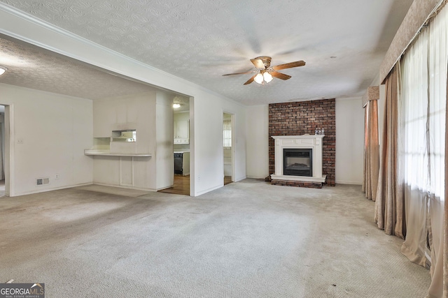 unfurnished living room with visible vents, a fireplace, baseboards, ceiling fan, and carpet flooring