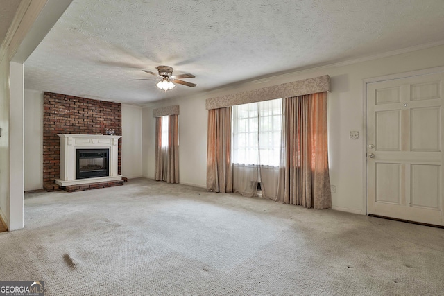 unfurnished living room featuring ceiling fan, carpet, a brick fireplace, and a textured ceiling