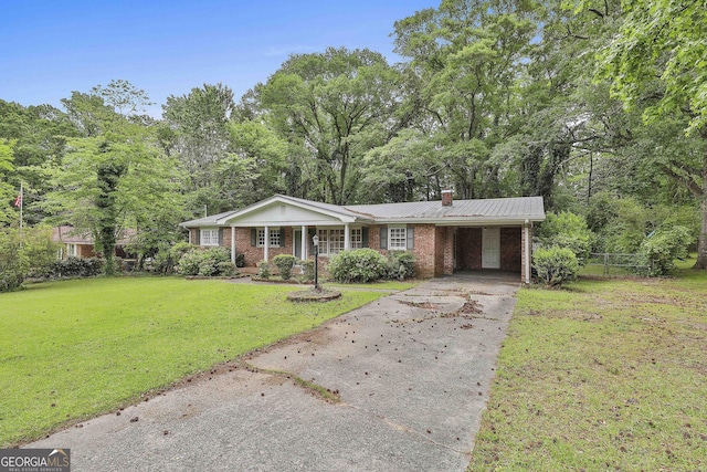 ranch-style home with a chimney, brick siding, fence, a front lawn, and concrete driveway