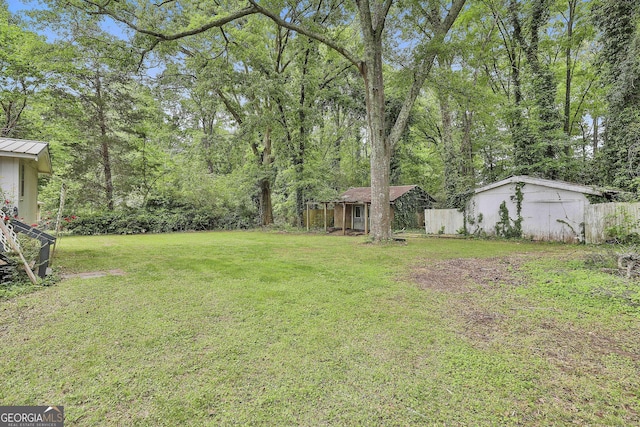 view of yard featuring fence and an outdoor structure