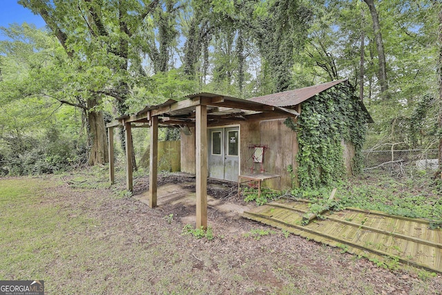 view of outbuilding with fence and an outbuilding