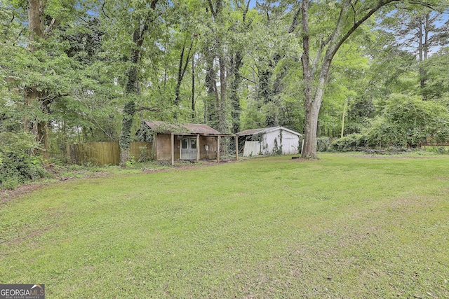 view of yard with fence and an outbuilding
