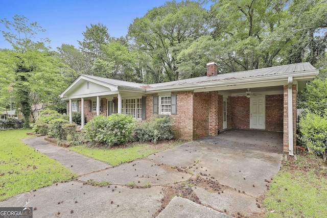 ranch-style home featuring an attached carport, a chimney, brick siding, a ceiling fan, and a porch