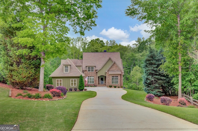 french country style house featuring concrete driveway, board and batten siding, and a front lawn
